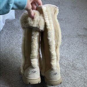 UGG cream colored tall boots with fur on outside.